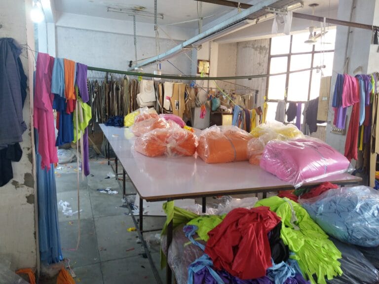 Rolls of packaged fabric on the cutting table at the GYMHUR activewear factory in Sialkot, Pakistan