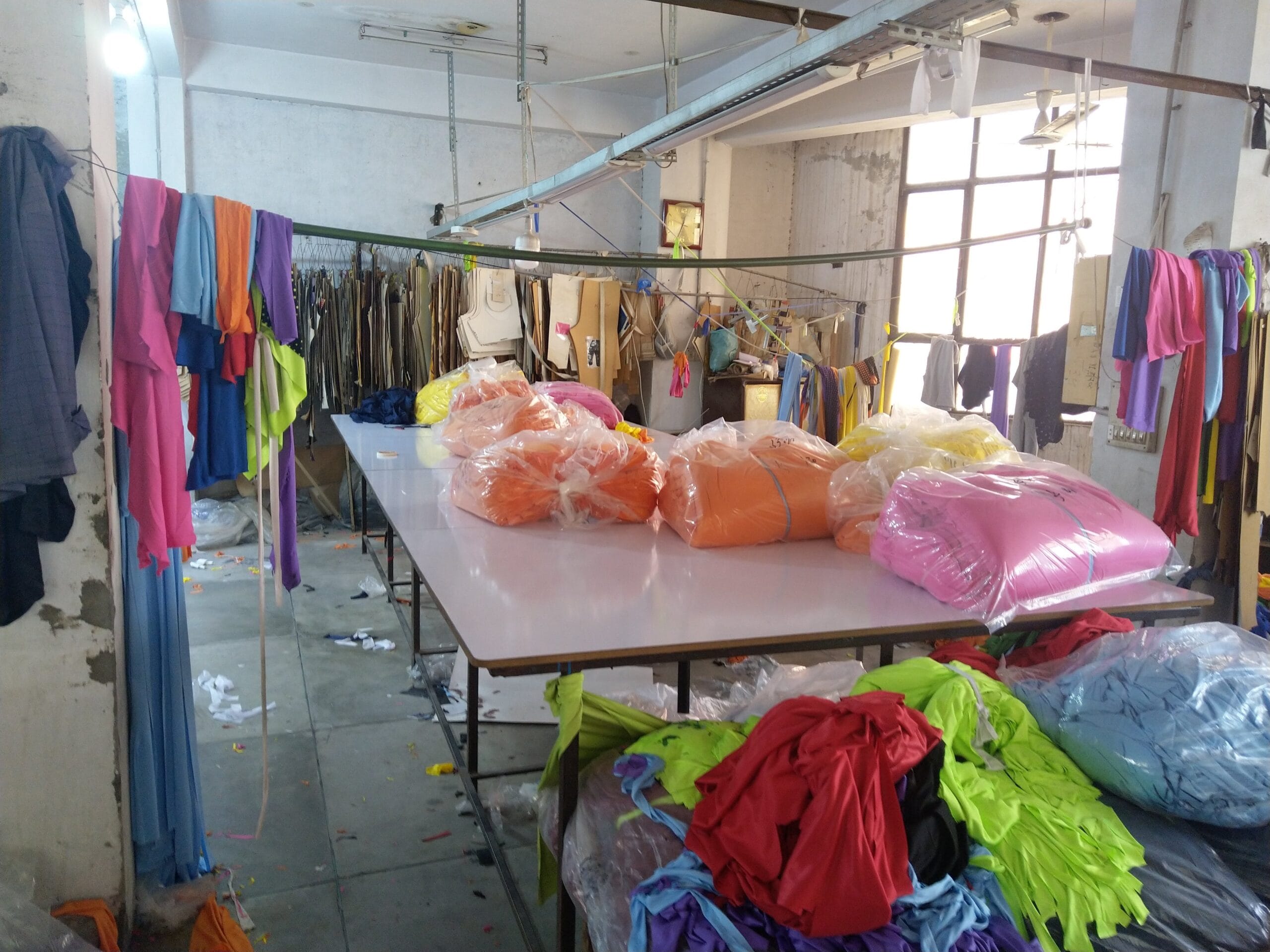 Rolls of packaged fabric on the cutting table at the GYMHUR activewear factory in Sialkot, Pakistan